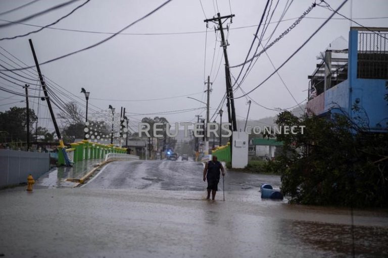 Un hombre vadea una calle inundada después de que el huracán Fiona afectó la zona en Yauco en Puerto Ricojpg