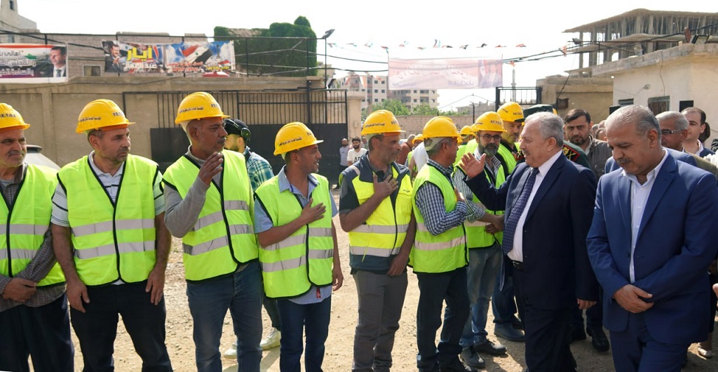 primer ministro sirio, Hussein Arnous, con los trabajadores de la subestación eléctrica recuperada