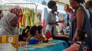 La fabricante de juguetes senegalesa Awa Gaye presenta sus muñecas a una niña en su stand, en Dakar, Senegal / Foto: REUTERS/Ngouda Dione Derechos de licencia de compra