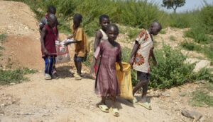 Juliet Samaniya de 6 años lleva una bolsa de litio junto a otros niños en un sitio de minería ilegal en Paseli Nigeria. | Foto: AP/Sunday Alamba