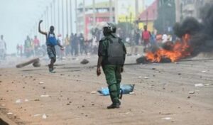Un policía observa mientras manifestantes bloquean calles y lanzan piedras en la capital de Guinea. Foto: Archivo/afp_tickers